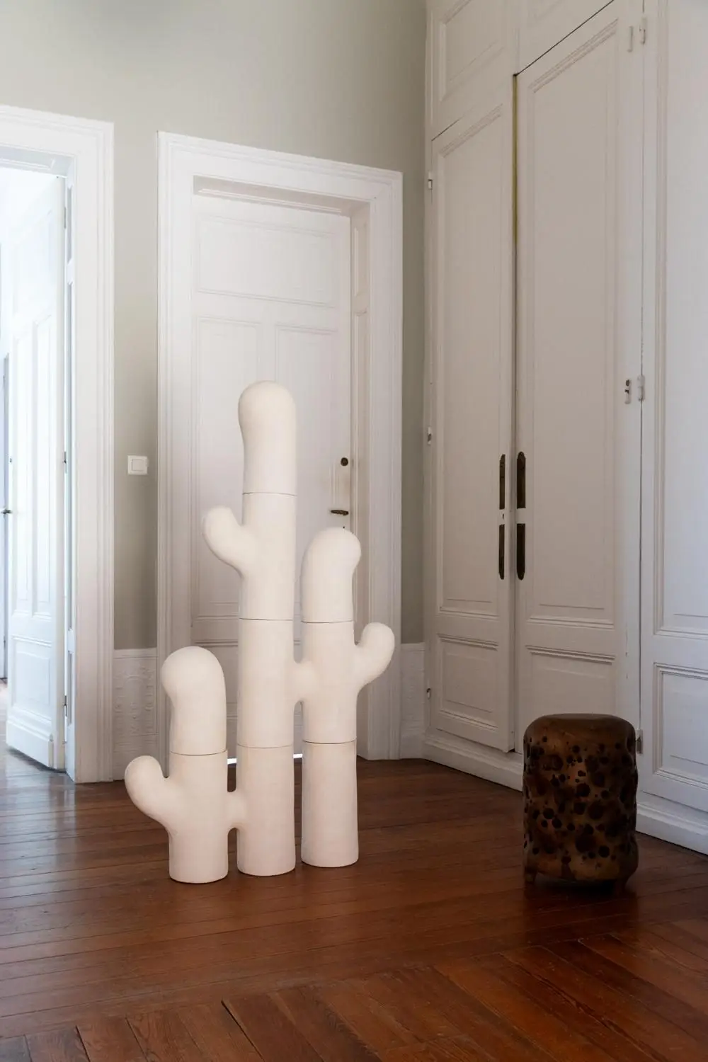 Sculpture Assemblance #1 d'Elisa Uberti en grès blanc, composition verticale évoquant un cactus stylisé à plusieurs branches, installée dans l'entrée d'une maison ancienne.