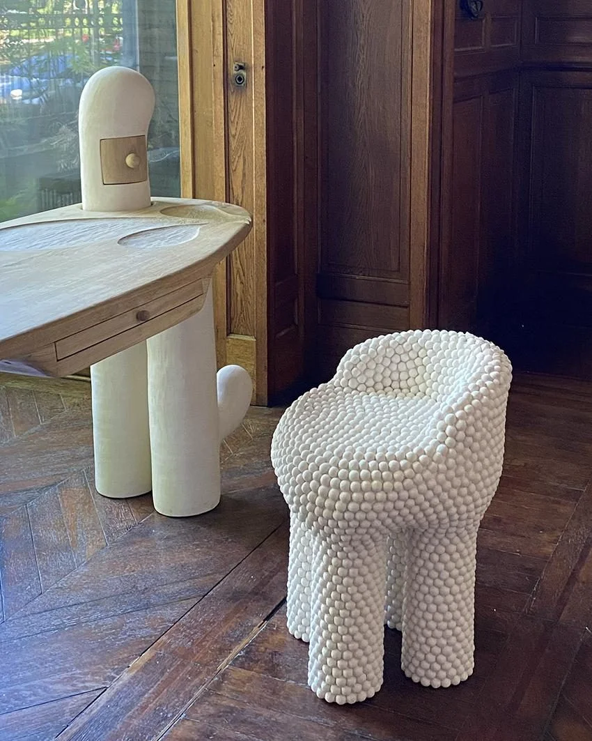 Sculpture Nuée #2 d'Elisa Uberti, tabouret en grès blanc entièrement recouvert de petites sphères en relief, posé sur un parquet ancien.
