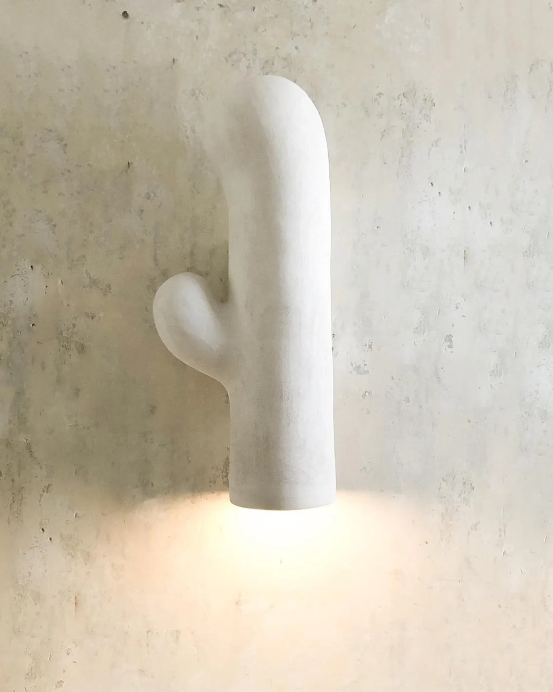 Applique murale Sconce Orée #1 d'Elisa Uberti en grès blanc, forme organique en cactus diffusant une lumière chaude vers le bas.