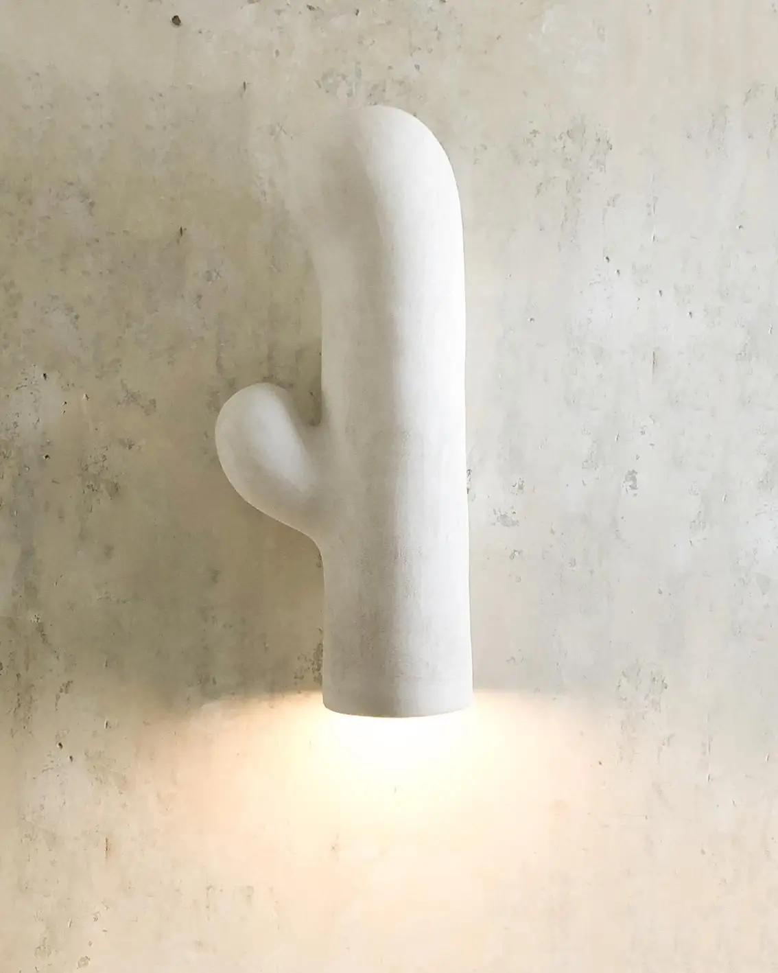 Applique murale Sconce Orée #1 d'Elisa Uberti en grès blanc, forme organique en cactus diffusant une lumière chaude vers le bas.